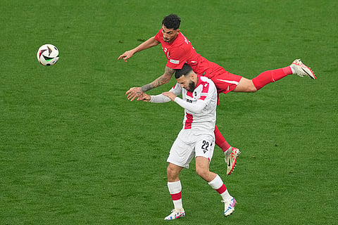 Samet Akaydin challenges for the ball with Georges Mikautadze 